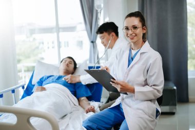 Hastanedeki meslektaşları ve hastalarıyla dijital tablet ve çizelge kullanan bir doktor.