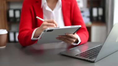 Yeni İş Projesi 'nde çalışan genç kadın muhasebe müdürü. Ofiste dijital tablet ve dizüstü bilgisayar kullanan iş kadını