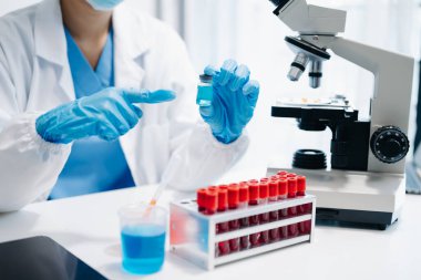 Kadın araştırmacı kimya laboratuvarında bir deney yürütüyor.