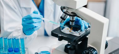 Modern tıbbi araştırma laboratuvarı. Kadın bilim adamı mikro pipetlerle çalışıyor biyokimyasal örnekleri analiz ediyor, tıp için ileri bilim kimya laboratuvarı.