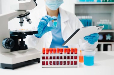 Kadın araştırmacı kimya laboratuvarında bir deney yürütüyor.