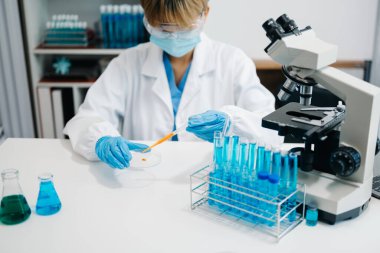 Modern tıbbi araştırma laboratuvarı. Kadın bilim adamı mikro pipetlerle çalışıyor biyokimyasal örnekleri analiz ediyor, tıp için ileri bilim kimya laboratuvarı.