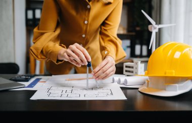 İşadamı, ofisteki masada mimarlık projesinde çalışıyor. 