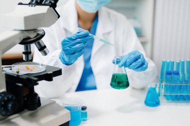 Modern tıbbi araştırma laboratuvarı. Kadın bilim adamı mikro pipetlerle çalışıyor biyokimyasal örnekleri analiz ediyor, tıp için ileri bilim kimya laboratuvarı.