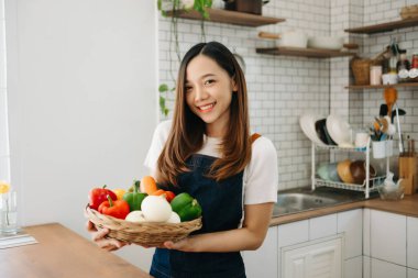 Taze dolmalık biberler bir kadının elinde. Evde karışık salata var.
