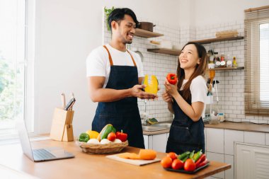 Sabah karısı ona sarılırken mutfakta ekmek ve meyveyle yemek hazırlayan bir adam.