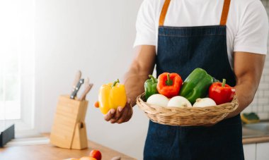 Erkek elleri evde taze dolmalık biber tutuyor.