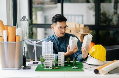 Mimari proje sahasında rüzgar enerjisiyle çalışan işadamı ve model ev yapıyor.