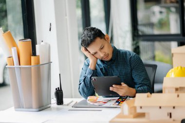 Modern ofisteki inşaat sahasında mimari projeyle büyük çizimlere yansıyan yaratıcı mimar