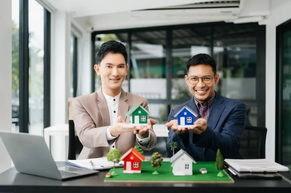 Salesman and customer with House Model in the office, Small Toy House Small Mortgage Property insurance and concepts real estate