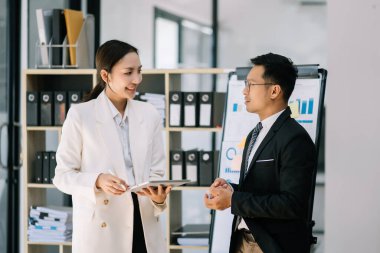 Nazik yönetici yönetici, Asyalı bayan pazarlama yöneticisiyle iş çözümlerini paylaşır ve tartışır..