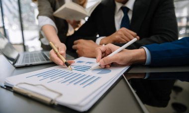 Ofis masası ve grafik işleri ile ilgili iş belgeleri sosyal ağ diyagramı ve ofiste çalışan verileri tartışan meslektaşlar