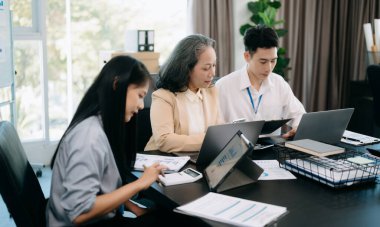 Nazik yönetici yönetici, Asyalı bayan pazarlama yöneticisiyle iş çözümlerini paylaşır ve tartışır..