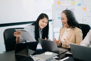 Nazik yönetici yönetici, Asyalı bayan pazarlama yöneticisiyle iş çözümlerini paylaşır ve tartışır..