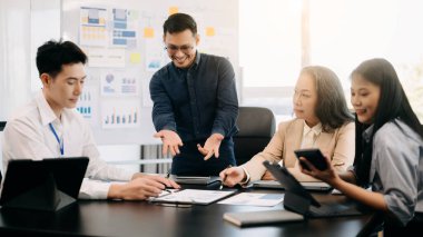 Ofiste yeni bir proje üzerinde çalışırken mutlu iş adamları. Ofiste bir dizüstü bilgisayar ve tablet kullanan bir grup iş adamı.