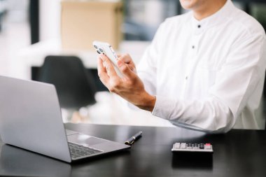 Modern ofiste bilgisayarla çalışan kendine güvenen bir iş adamı..