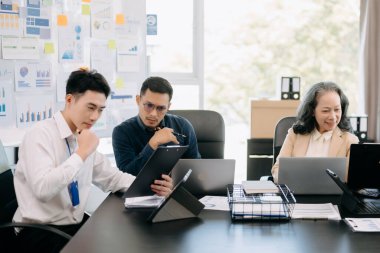 Ofiste dizüstü bilgisayar kullanan Asyalı işçiler