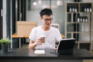 Genç adam dijital tablet çalışma yerini kullanıyor. İşine odaklan. Ofiste. 