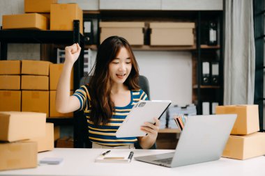 Başlangıçta küçük işletme KOBİ 'si, girişimci sahibi kadın paket ürün kutusu hazırlamak için online alışveriş siparişi alıyor ve kontrol ediyor. 