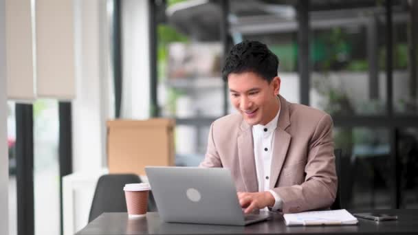 アジアのビジネスマンはオフィスのラップトップの仕事に喜び 幸せです — ストック動画