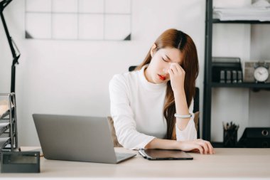 Ofis masasında uzun bir gün geçirdikten sonra boynu ağrıyan Asyalı genç işkadını ofis çalışanı. ofis sendromu kavramı