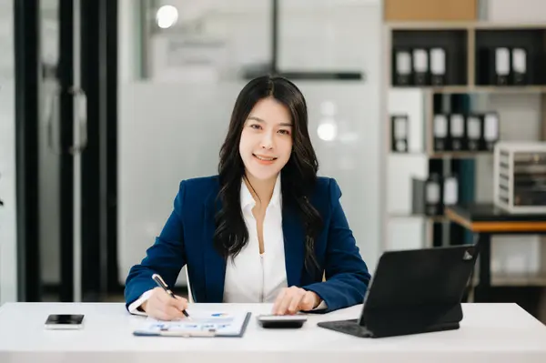 Confident business expert attractive smiling young woman working on desk in creative office