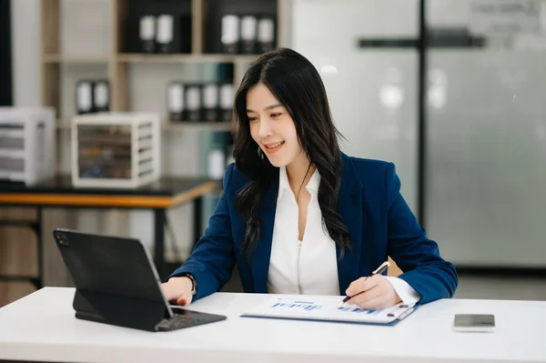 Confident business expert attractive smiling young woman using digital tablet on desk in creative office