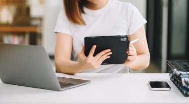 Ofis masasında, vergi, rapor, muhasebe, istatistik ve analitik araştırma konseptinde matematik finansmanı yapmak için dizüstü bilgisayar ve tablet kullanan iş kadını