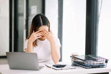Ofis masasında uzun bir gün geçirdikten sonra boynu ağrıyan Asyalı genç işkadını ofis çalışanı. ofis sendromu kavramı
