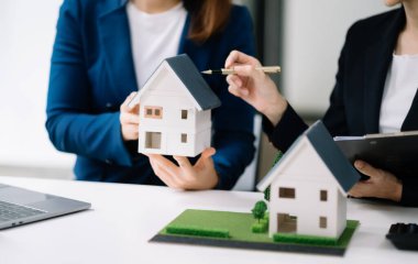 Salesman Hands On House Model , Small Toy House Small Mortgage Property insurance and concepts real estate in office