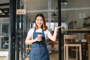 Kafe restoranında siparişleri almaya hazır genç Asyalı kadın kahve dükkanı sahibi. Kadın kahveci kafe.