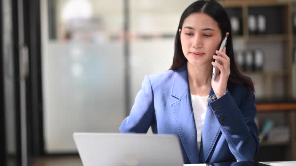 Asiatische Geschäftsfrau Arbeitet Mit Laptop Und Spricht Büro Über Smartphone — Stockvideo