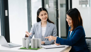  Kontrat imzalıyorum. Müşteri ve komisyoncu, kira sözleşmesi, başarılı bir anlaşma. Ofisteki masada oturan genç iş adamları.