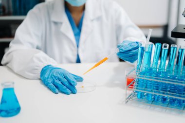 Modern tıbbi araştırma laboratuvarı. Kadın bilim adamı mikro pipetlerle çalışıyor biyokimyasal örnekleri analiz ediyor, tıp için ileri bilim kimya laboratuvarı.