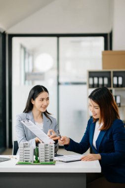  Kontrat imzalıyorum. Müşteri ve komisyoncu, kira sözleşmesi, başarılı bir anlaşma. Ofisteki masada oturan genç iş adamları.