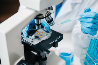 Modern tıbbi araştırma laboratuvarı. Kadın bilim adamı mikro pipetlerle çalışıyor biyokimyasal örnekleri analiz ediyor, tıp için ileri bilim kimya laboratuvarı.