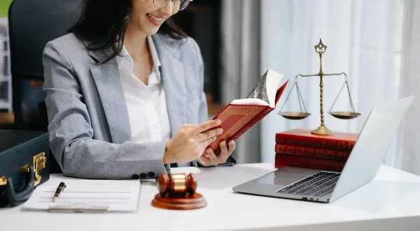 女性弁護士は法律書を読み 机の上に砂利を敷く 正義と法弁護士の概念 ストック画像