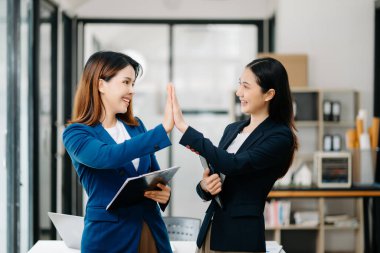 Asyalı iş arkadaşı sunar ve yeni projeyi açıklar. Takım çalışması, finansal pazarlama ekibi modern ofis odasında.. 