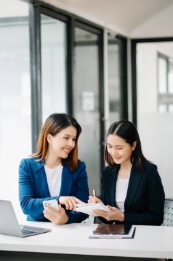 Asyalı iş arkadaşı sunar ve yeni projeyi açıklar. Takım çalışması, finansal pazarlama ekibi, modern ofis odasında otururken. 