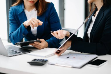 Asyalı iş arkadaşı sunar ve yeni projeyi açıklar. Takım çalışması, finansal pazarlama ekibi, modern ofis odasında otururken. 