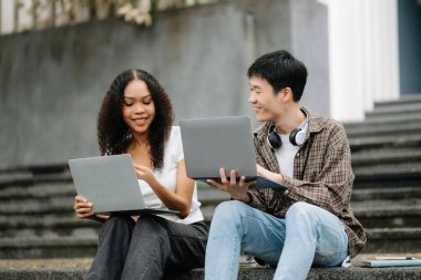 Kampüs parkındaki aletleri kullanarak birlikte okuyan genç üniversite öğrencileri.