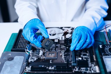 Teknisyen işlemciyi ana bilgisayarın prizine yerleştiriyor. Elektronik mühendislik, elektronik onarım, elektronik ölçüm ve test, atölyede onarım