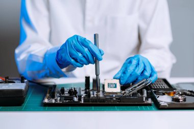 Teknisyen laboratuardaki ana kartı fotokopi aletiyle onarıyor. bilgisayar donanımı konsepti, elektronik, onarım, mavi efekt