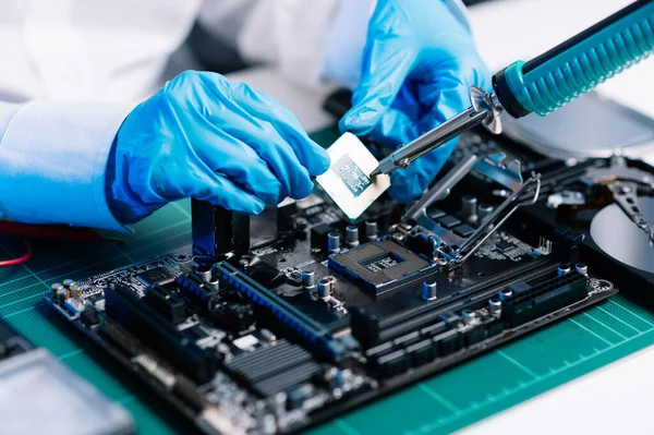 The technician repairing the motherboard in the lab with copy space. the concept of computer hardware, electronic, repairing, upgrade blue effect