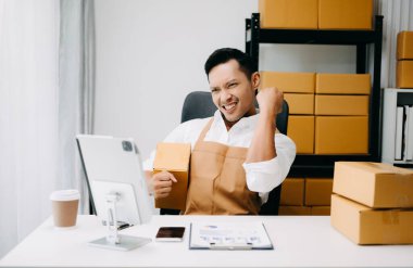 Başlangıçta küçük işletme KOBİ 'si, girişimci sahibi paket ürün kutusu hazırlamak için çevrimiçi alışveriş siparişini alıp kontrol ediyor. 