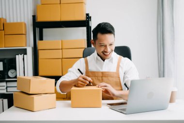 Çevrimiçi mağaza işleten genç adam Başlangıç küçük işletme KOBİ, ofisteki online satın alma siparişini alır ve kontrol eder