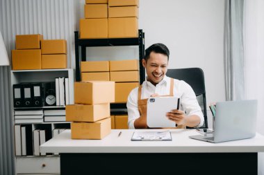 Başlangıçta küçük işletme KOBİ 'si, girişimci sahibi paket ürün kutusu hazırlamak için çevrimiçi alışveriş siparişini alıp kontrol ediyor. 