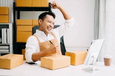 Başlangıçta küçük işletme KOBİ 'si, girişimci sahibi paket ürün kutusu hazırlamak için çevrimiçi alışveriş siparişini alıp kontrol ediyor. 