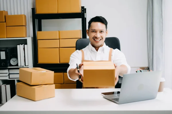 Young man running online store Startup small business SME, taking receive and checking online purchase shopping order in office
