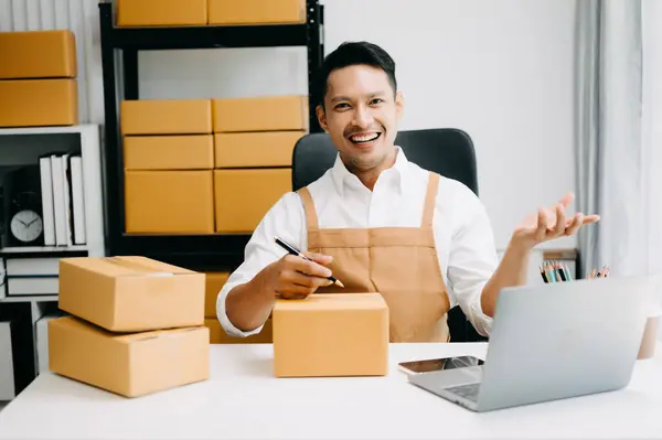 Young man running online store Startup small business SME, taking receive and checking online purchase shopping order in office
